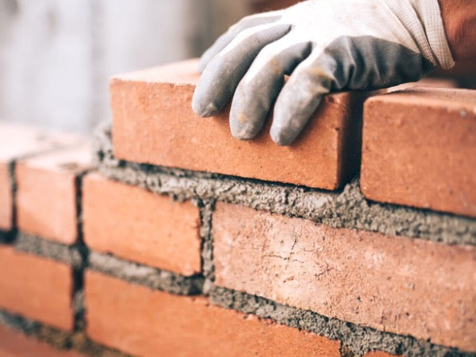 Bricklayer laying face brick with mortar