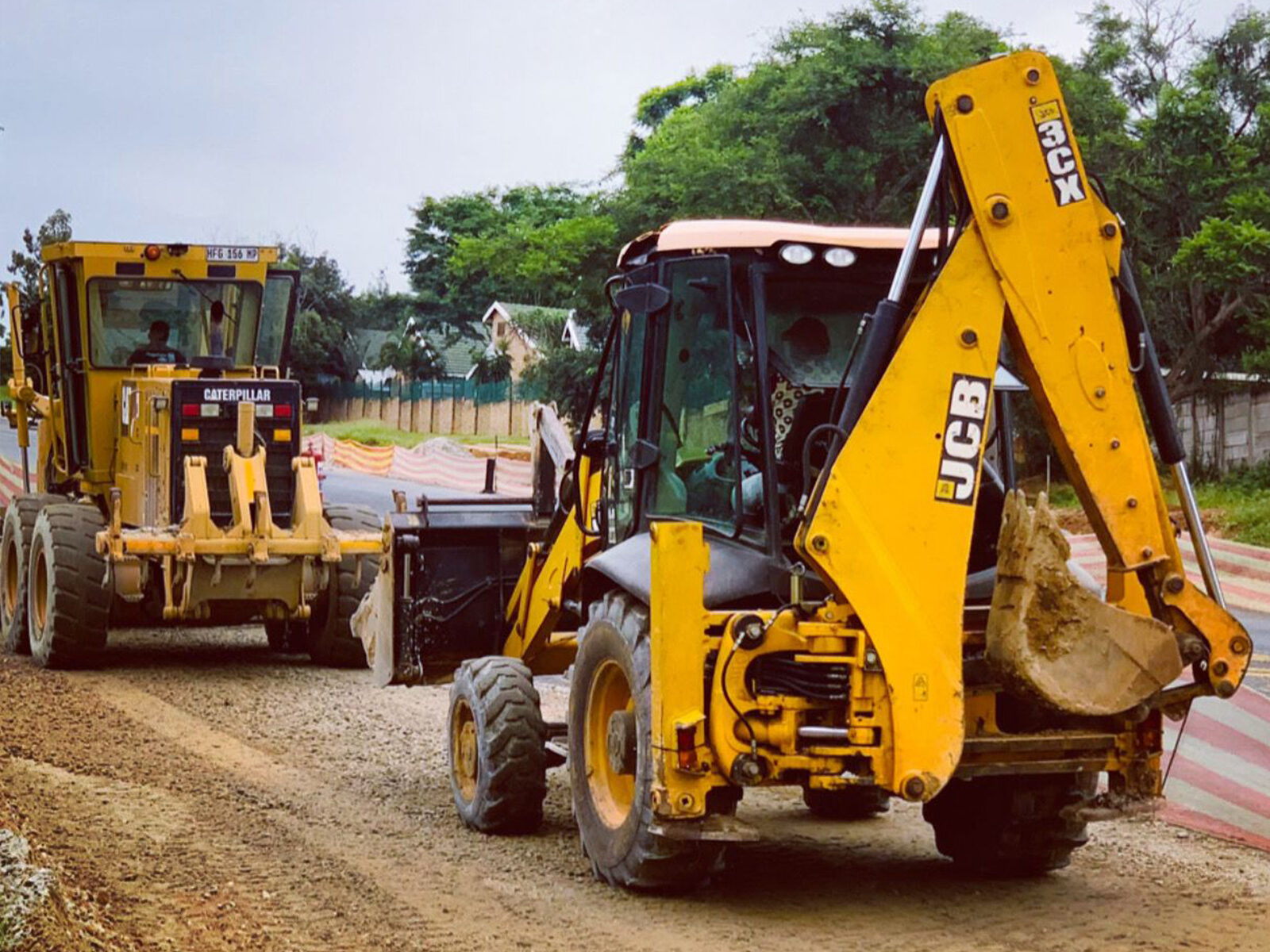 JCB TLB and Caterpillar grader on a road layer works